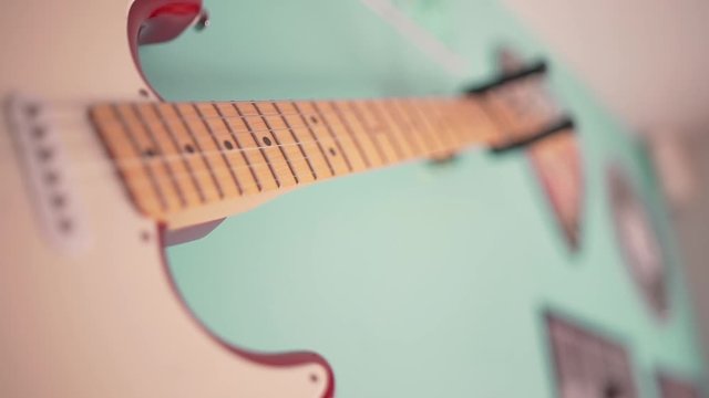 A vintage retro electric guitar from the fifties hanging on the wall in an american fifties bar filmed in close up on the snares.