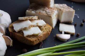 Bread with salted bacon and onions. Garlic on the table. Lunch, dinner. Meal.
