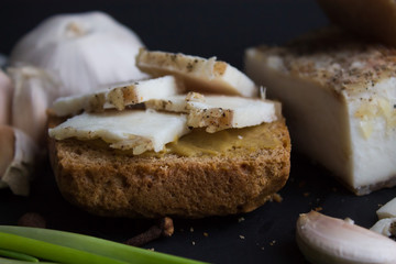 Bread with salted bacon and onions. Garlic on the table. Lunch, dinner. Meal.