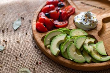 Rustic close up of cherry tomatoes and avocado for concept design. Concept of healthy eating. Fresh fruit and vegetables.Fresh and summer items. Food set. Natural wooden background.