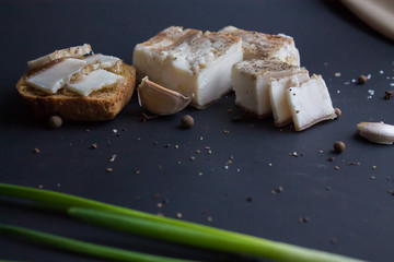 Bread with salted bacon and onions. Garlic on the table. Lunch, dinner. Meal.