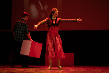 Dancer in a red dress dancing Spanish flamenco on the stage in the theater