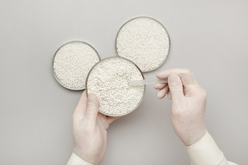  laboratory assistant taking a sample from a new batch of white plastic polymer