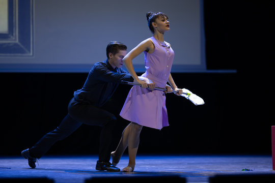 A pair of dancers a man and a woman perform in a theater on stage in a dance musical show.