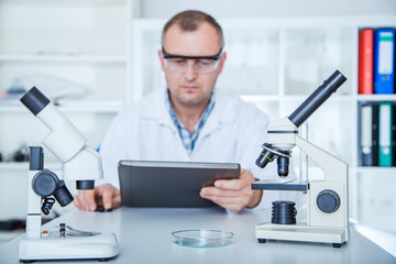 Obraz premium Researcher working in lab with microscope, researcher in biochemical lab