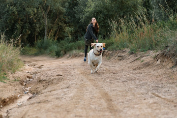Naklejka na ściany i meble Girl walking a dog in the country