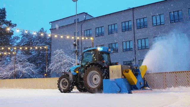 machines, season and winter concept - tractor with ice resurfacer or snow blower on outdoor skating rink