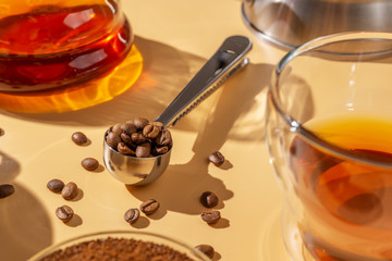 Metal spoon with roasted coffee beans, hard light, coffee preparation
