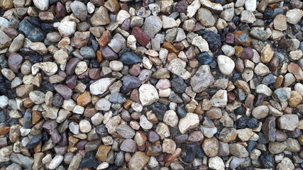 A pile of gray stones lie on the grass for the background, abstract
