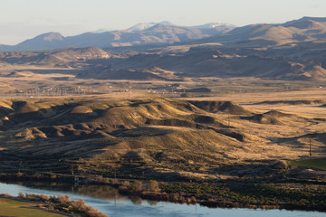 rolling hills of southern idaho by snake river with owyhees in background