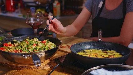 Woman cooking frying eating in kitchen in wok pan