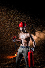 Asian muscular man black hair and bread serious face topless cross rescue rope on torso and holding fire axes in right hand standing in dark fire smoke and pouring rain background 