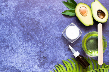 Two halves of avocado, avocado oil, fern leaf and massage stone. Natural Organic Product Beauty...