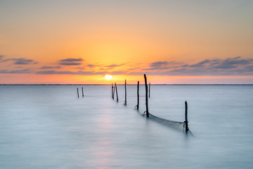 Obraz premium Fishing nets in a lake during the sunset