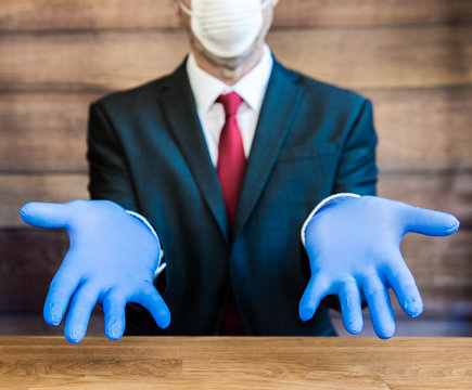 A Doctor Or Businessman With Outstretched Hands And Wearing Ppe Blue Surgical Gloves And Face Mask Demonstrating The Global Shortage With Copy Space