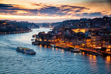 Porto, Portugal: Evening view of Porto cityscape and the Douro River with traditional Rabelo boats, seen from the Dom Luis bridge after sunset