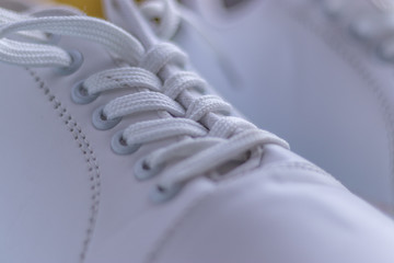 White sneakers on light blue colour background, flat lay top view minimal background. 
