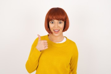 Good job! Portrait of a happy smiling blue eyed young successful woman giving thumb up gesture standing outdoors. Positive human emotion facial expression body language. Funny girl