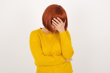 Indoor portrait of beautiful woman with stylish haircut, wearing casual clothes, making facepalm...