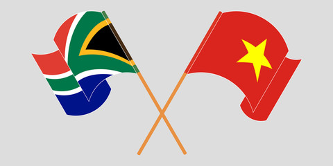 Crossed and waving flags of South Africa and Vietnam
