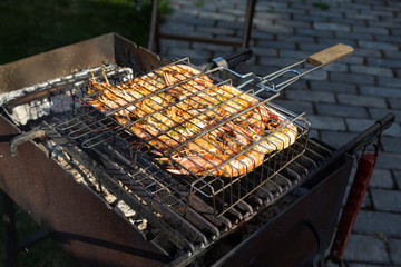 large pink shrimps langoustines with carapace lie on the grill with smoke. BBQ outdoor. Summer time.