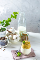 Glass of Iced Dalgona Coffee, a trendy fluffy creamy whipped coffee, decorated by mint and ingredients on light rustic background, copy space