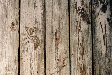 Texture of gray shabby wooden fence from old vertical boards with peeling paint