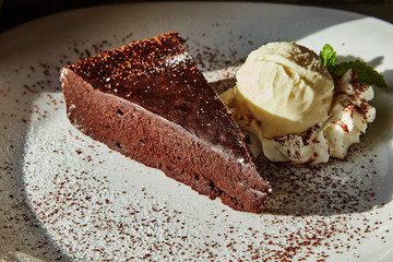 A piece of brownie cake and ice cream on a plate