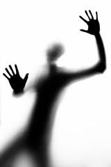 persona in silhouette (b/w) fotografata attraverso un vetro mostra i palmi delle mani - obrazy, fototapety, plakaty