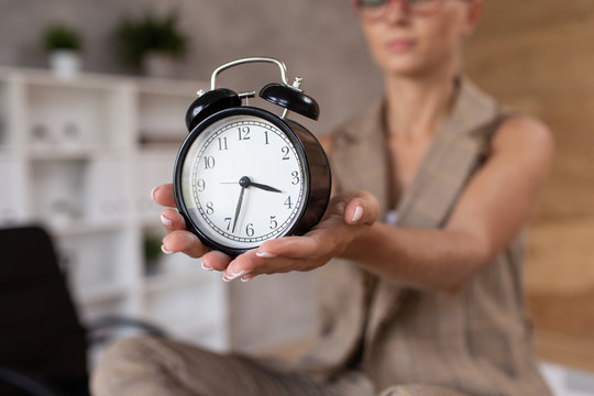 Closeup of mechanical clocks in hands of young blond woman