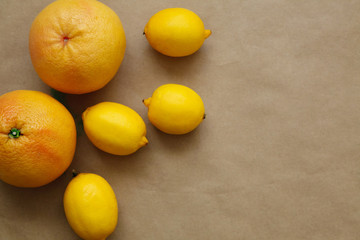 Flat lay of ripe fresh citrus fruits on the brown background. Healthy life style concept. Delivery concept. 