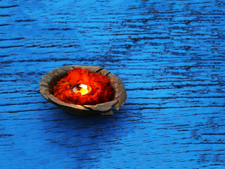 Burning pooja candle at aarti ceremony on the river Ganges, Varanasi, India on blue boat material