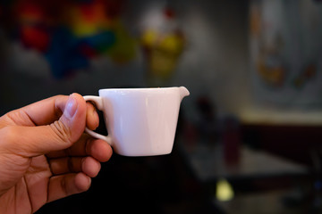 cup of coffee in hand on abstract background.