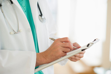 Male doctor writing medical report