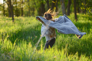 happy child girl with a kite running on meadow in summer in nature. 9 year old girl running on meadow with sunset. happy girl in nature with fabric. Spring picnic