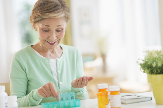 Senior woman organizing medicine in box