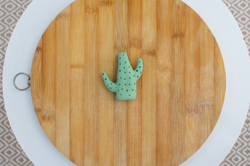figura en forma de cactus encima de una tabla  de madera