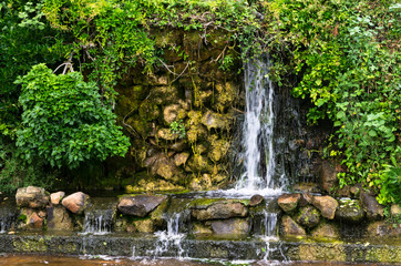 Landscape waterfall overgrown with plants