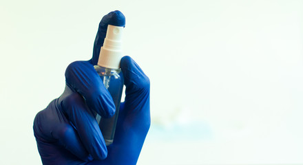 a hand in a green medical glove applying a disinfectant or antiseptic gel to protect against infectious viruses, bacteria and germs, pours onto a hand without a glove on a white background