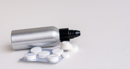 Tablets fall out of the pill bottle and stand out against a gray background. Side view with space for copying. Concept of medicine