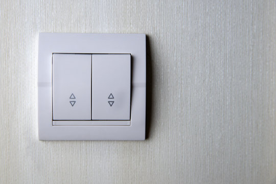 Two-key switch gray on the wall a plastic mechanical switch. Light switch installed after repair. The concept of energy savings. Closeup of Light Switch with copy space to the side