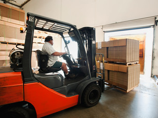 Forklift truck loading pallets into trailer