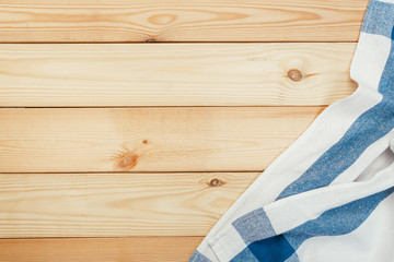 Top view on a wooden table with a linen kitchen towel or textile napkin.