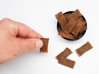 Open can of smokeless tobacco with man hand on white background