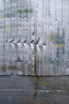 Row of indentation marks on silver spray painted metal wall, close up