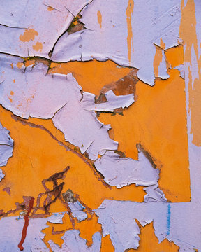 Detail of peeling paint and markings on colorfully painted industrial cargo container