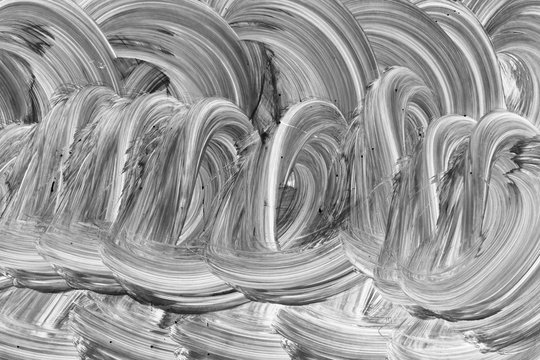 Paint and brush strokes covering glass, surface pattern close up