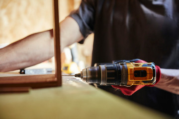 Carpenter using drill on woodwork