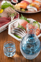japanese sake in glass bottle with sushi and sashimi