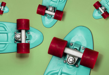 Turquoise Skateboards on green background, top view. Concept of sport lifestyle, culture, leisure,...